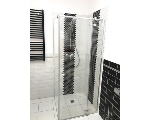 Inloopdouche met glazen wand en zwarte radiator in de badkamer.