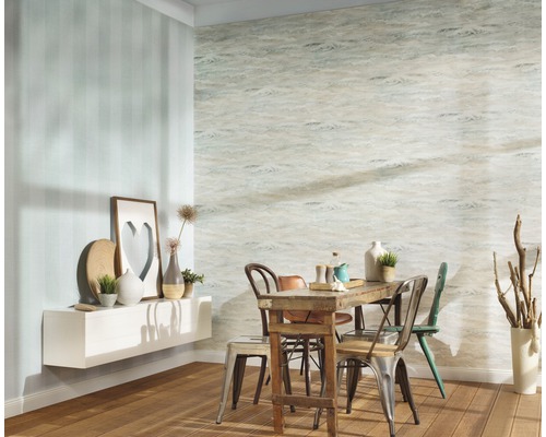 Eetkamer met houten tafel en stoelen tegen een muur met patroon en een muur met strepen