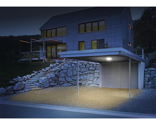 Verlichte carport bij een modern woonhuis met stenen trap