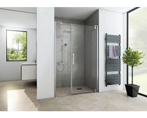 Badkamer met douche, handdoekradiator en raam voor een heldere sfeer.