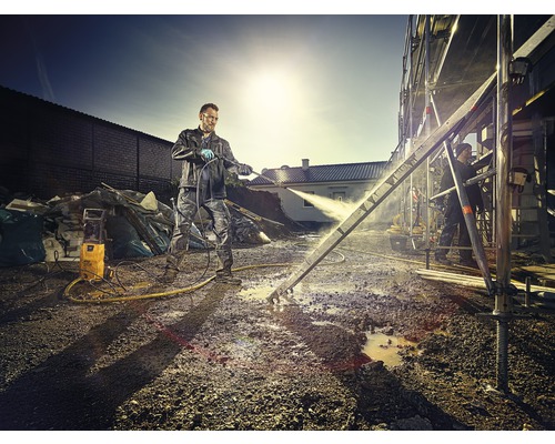 Man reinigt bouwsteiger met hogedrukreiniger op bouwplaats