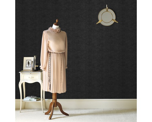 Een kamer met een etalagepop, een tafeltje en een muur met een dierenhuidmotief