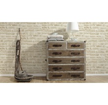 Ladekast met zes lades, lamp en decoratieve manden voor een bakstenen muur