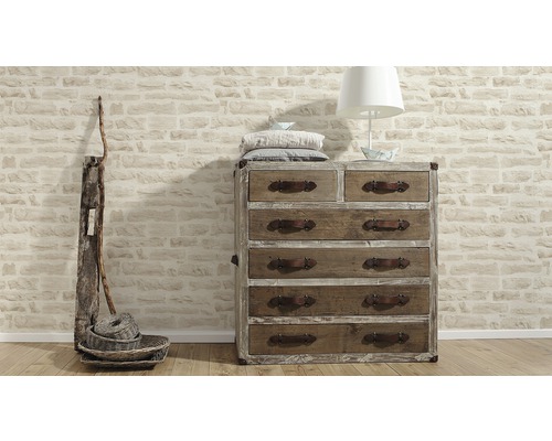 Ladekast met laden, lamp, kussens en decoratie voor een stenen muur