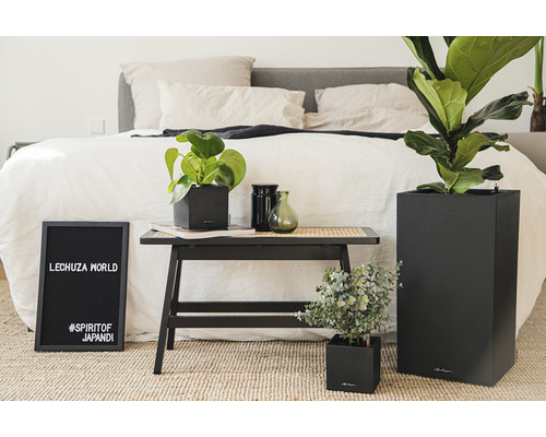 Decoratieve kamerplanten in Lechuza plantenbakken naast een bed.