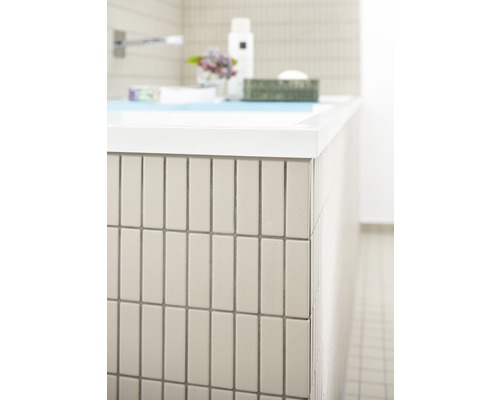 Detail van een badkamer met rechthoekige wandtegels.