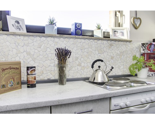 Keukenscène met mozaïekwand, waterkoker en decoratieve artikelen op het aanrecht