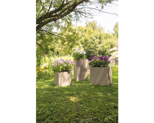 Drie plantenbakken met bloemen in de tuin