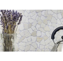 Decoratieve wand met natuursteen mozaïektegels in een interieur, aangevuld met lavendel in een glazen vaas en een roestvrijstalen ketel.