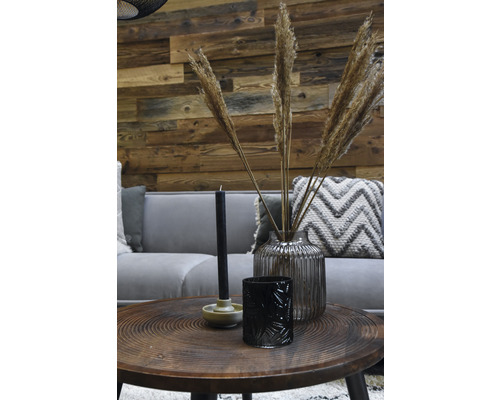 Decoratieve woonkamer met bank, tafel en accessoires zoals kaarsen, windlicht en een vaas met siergras