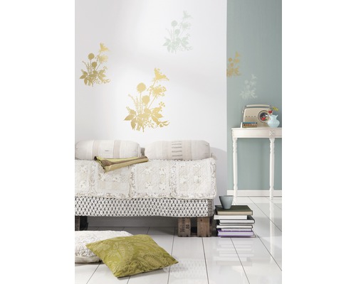 Decoratieve woonkamer met bloemenmuurstickers, palletbed en vintage radio op een tafel