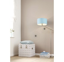 Lichte kamer met witte kist, kussen, staande lamp en decoratie