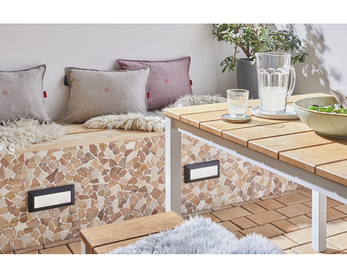 Terras met zitbank, kussens, tafel, servies en buitenverlichting