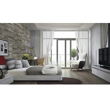 Slaapkamer met bed, bureau, fauteuil en televisie