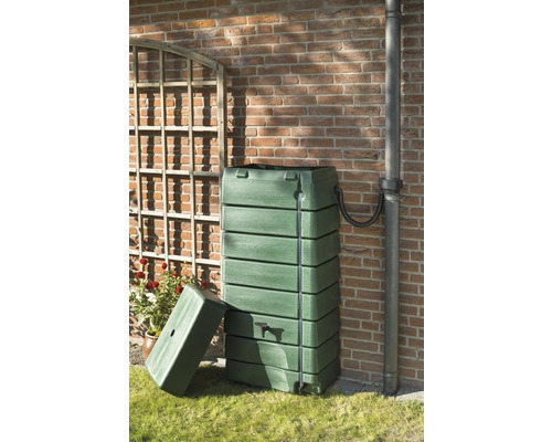 Regenton van kunststof met deksel en aftapkraan voor een bakstenen muur