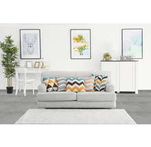 Woonkamer met bank, kussens, vloerkleed, tafel, stoel, commode en decoratie