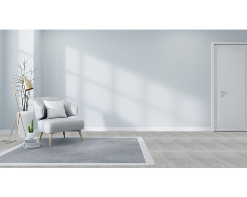 Lichte kamer met fauteuil, vloerkleed en staande lamp