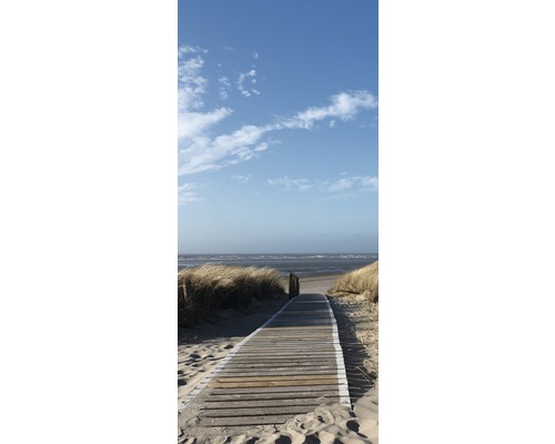 Houten steiger leidt naar het strand onder een blauwe hemel