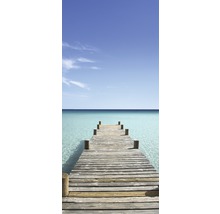 Houten steiger leidt naar heldere, turquoise zee onder blauwe hemel
