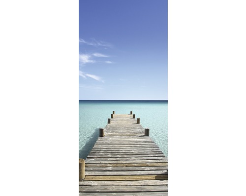 Houten steiger leidt naar heldere, turquoise zee onder blauwe hemel