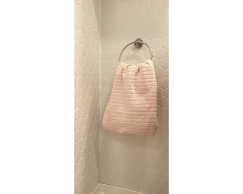 Handdoekhouder met handdoek aan wandtegels