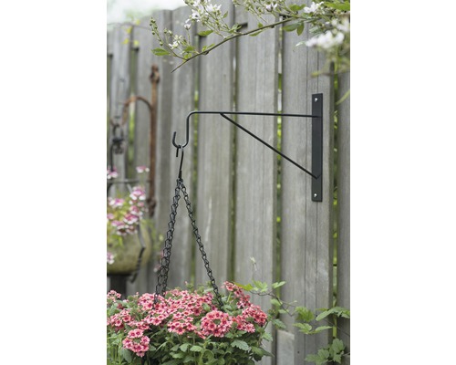 Hangbloemen aan een beugel aan een houten schutting