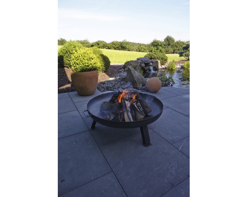 Vuurplaats met brandend hout in tuinomgeving