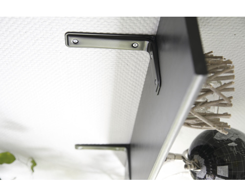 Zwarte wandplank met beugels aan een witte muur