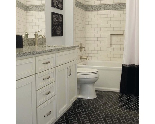 Badkamer met witte wastafel, toilet, bad en zeshoekige vloertegels