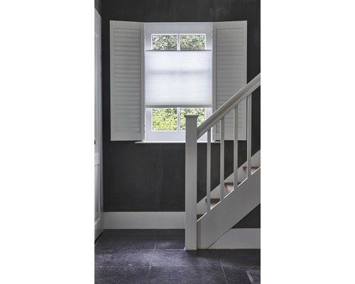 Interieurscène met raam, luiken, plisségordijn en trap.