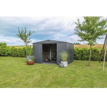 Tuinscene met metalen tuinhuis, tuingereedschap, ladder en planten
