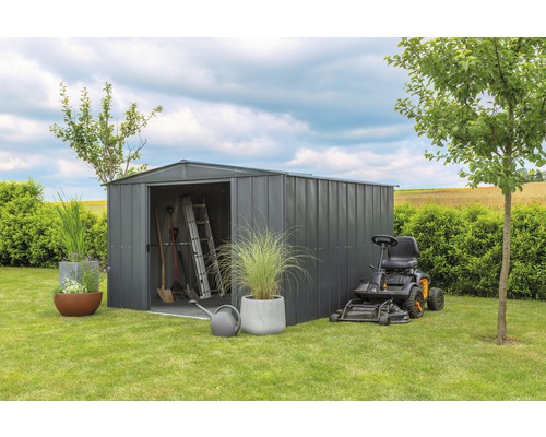 Tuin scène met gereedschapsschuur, gazontractor en tuingereedschap op gazon