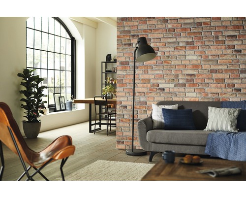 Woonkamer met bank, staande lamp en bakstenen muurbehang