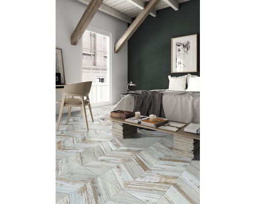 Slaapkamer met lichte houten vloer in visgraatmotief, bed en bureau.