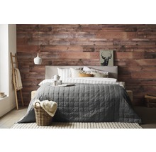 Slaapkamer met houten wand, bed, deken en decoraties