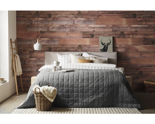 Slaapkamer met houten wand, bed, deken en decoraties