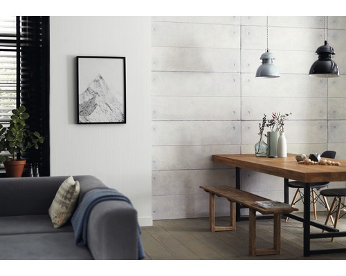 Woonkamer met bank, eettafel, zitbank en wandpanelen in betonlook.