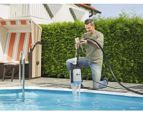 Man gebruikt een dompelpomp bij het zwembad om water af te voeren.