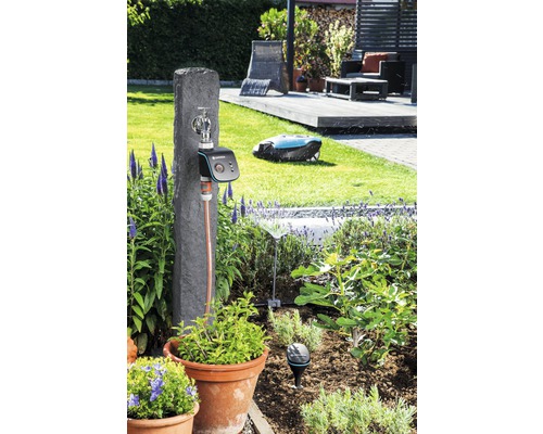 Tuin met irrigatiesysteem, waterkraan, robotmaaier en planten