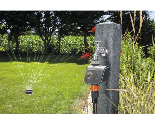 Tuinscene met irrigatiesysteem met timer en sproeier