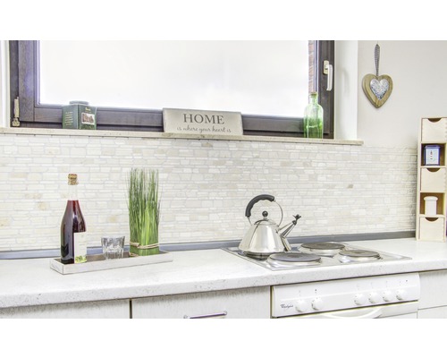 Lichte keuken met betegelde wand, drankjes en keukengerei op het aanrecht