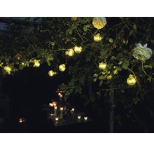 Decoratieve tuinverlichting met lichtslinger en kaarsen op tafel