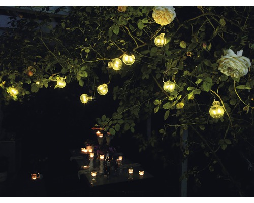 Decoratieve tuinverlichting met lichtslinger en kaarsen op tafel