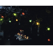 Tuinverlichting met gloeilampen en tafeldecoratie in het donker.