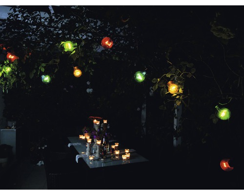 Tuinverlichting met gloeilampen en tafeldecoratie in het donker.