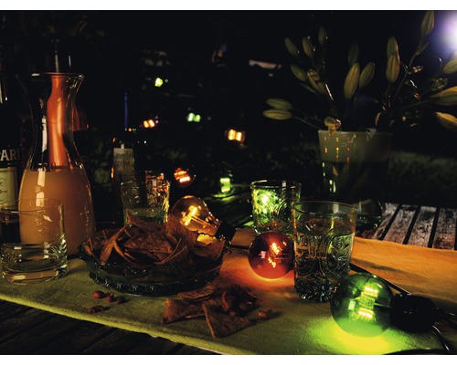 Avondtuinscène met drankjes, snacks en decoratieve verlichting.