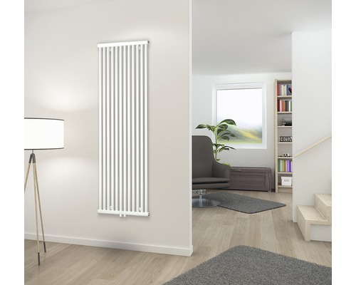 Verticale radiator aan de muur in de woonkamer.