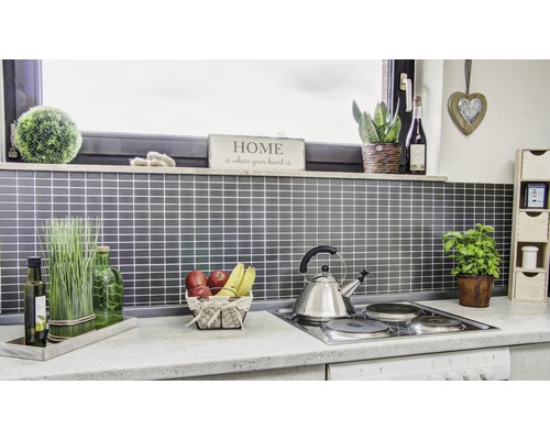 Keukenscène met accessoires en keukengerei op een werkblad voor een betegelde wand