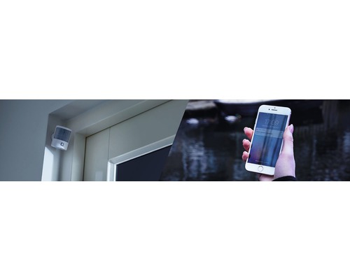 Bewegingsmelder aan een muur en een persoon die een melding ontvangt op een smartphone