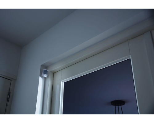 Bewegingsmelder binnenshuis gemonteerd aan een muur boven een deur